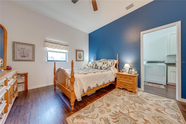 bedroom with washer / dryer, baseboards, visible vents, wood finished floors, and vaulted ceiling