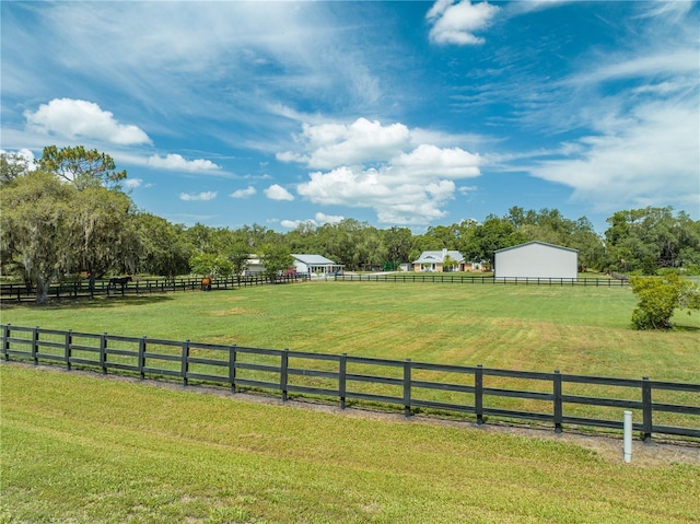 view of yard featuring a rural view and fence