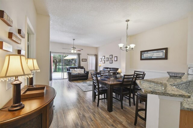 dining space featuring a textured ceiling, ceiling fan with notable chandelier, and hardwood / wood-style floors