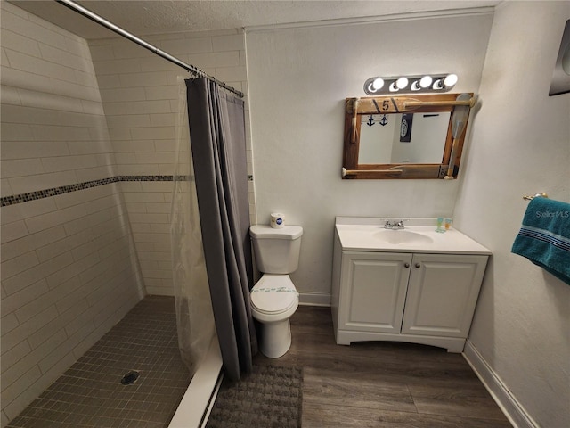 bathroom featuring a textured ceiling, wood-type flooring, a shower with curtain, vanity, and toilet