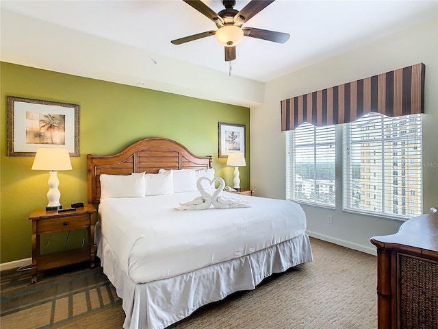 bedroom with ceiling fan and dark colored carpet