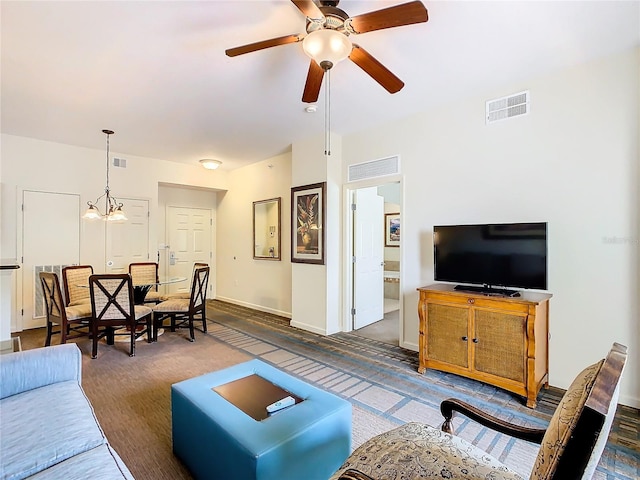 living room featuring ceiling fan with notable chandelier