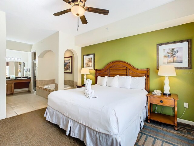 bedroom featuring ensuite bath, ceiling fan, and tile patterned flooring