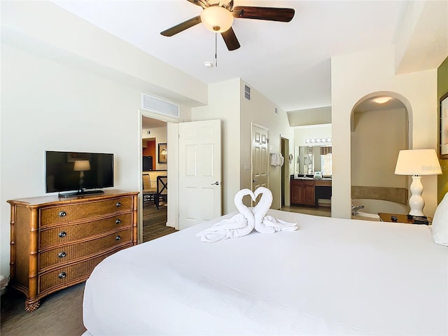 bedroom featuring connected bathroom, dark hardwood / wood-style flooring, and ceiling fan