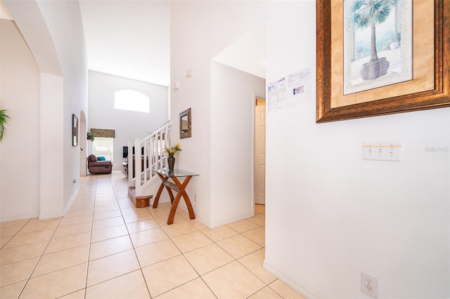 corridor with a towering ceiling and light tile patterned floors