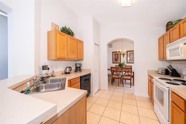 kitchen featuring sink, light tile patterned flooring, white appliances, and an inviting chandelier