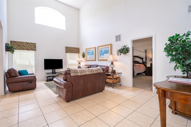 living room with light tile patterned floors and a high ceiling