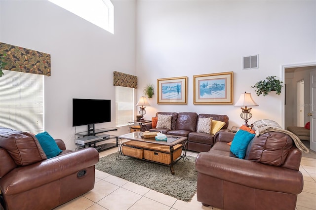 living room featuring light tile patterned flooring and a high ceiling