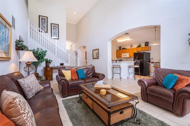 living room with light tile patterned flooring and a high ceiling