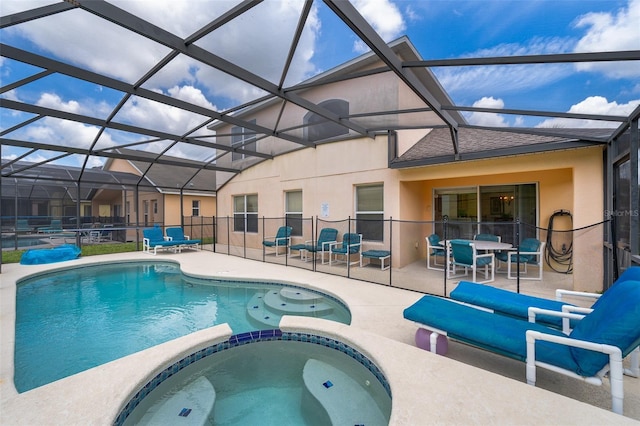 view of swimming pool with a lanai, a patio area, and an in ground hot tub