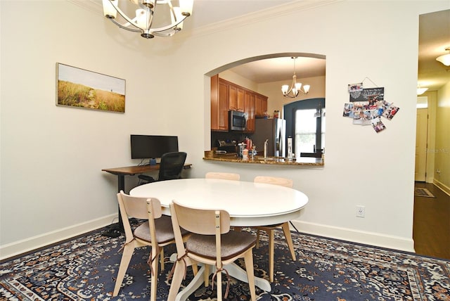 dining room with crown molding and a chandelier