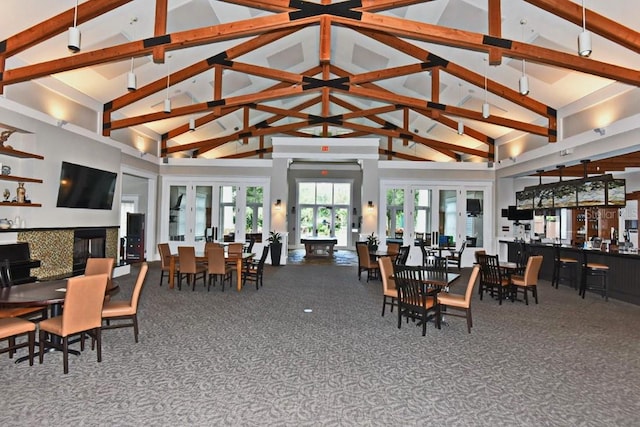 carpeted dining room featuring beamed ceiling and high vaulted ceiling