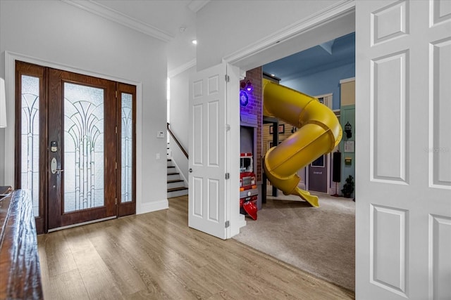 carpeted entryway with ornamental molding