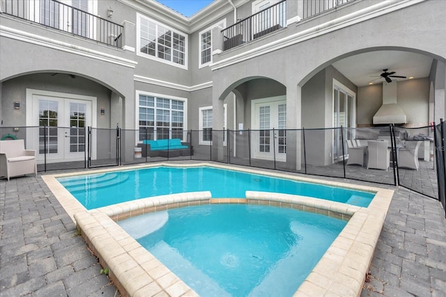 view of swimming pool featuring ceiling fan and french doors