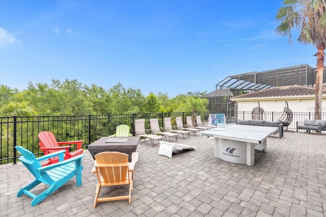 view of patio featuring a fire pit and a lanai