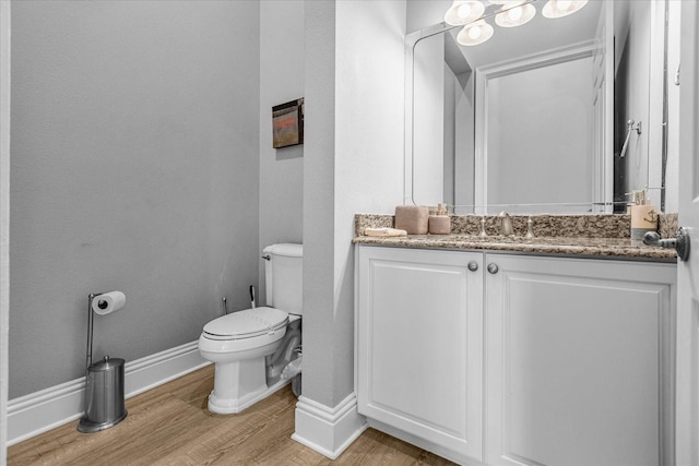 bathroom with vanity, toilet, and wood-type flooring