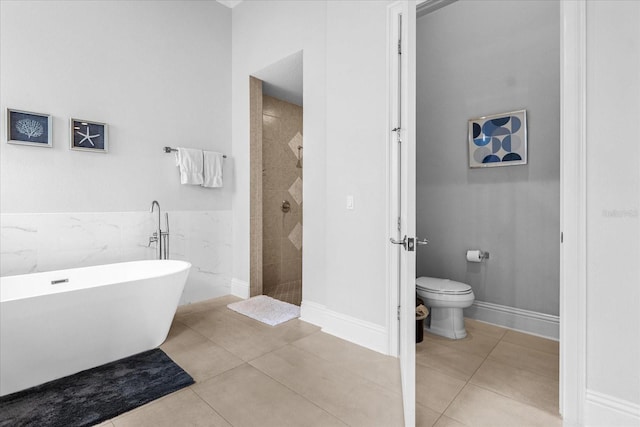 bathroom with toilet, independent shower and bath, tile patterned flooring, and tile walls