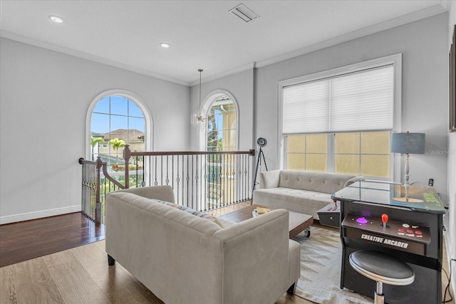 living room featuring a notable chandelier, crown molding, and hardwood / wood-style flooring