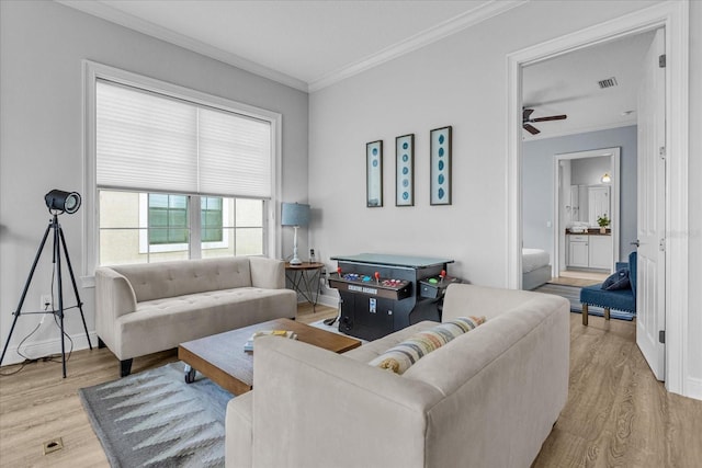 living room featuring crown molding and light hardwood / wood-style floors