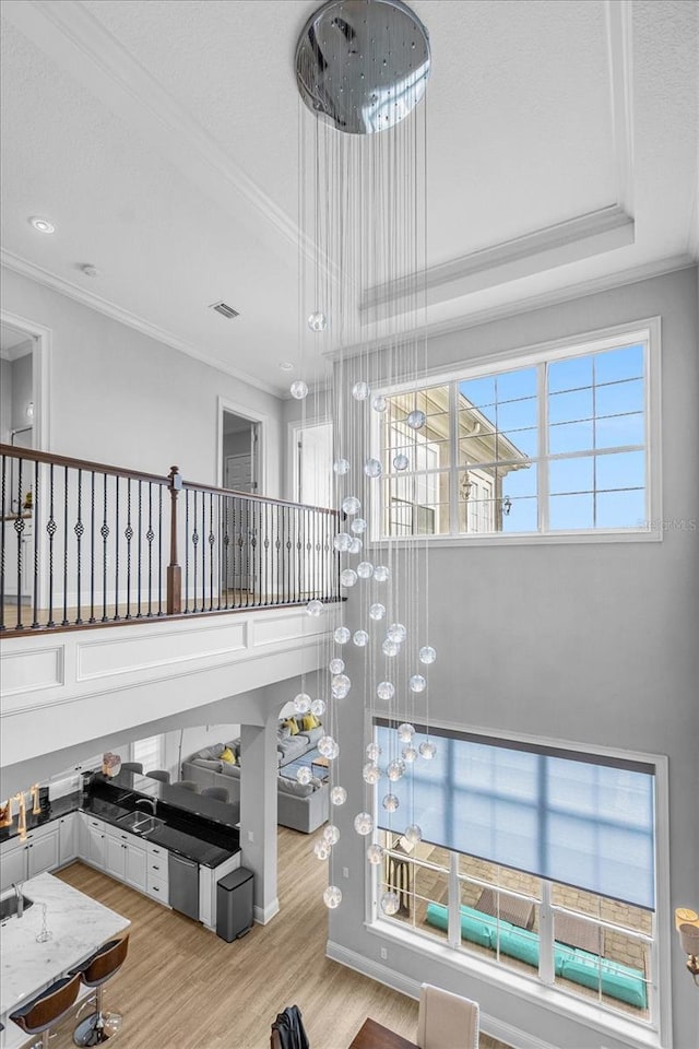 staircase with crown molding, a tray ceiling, and hardwood / wood-style flooring