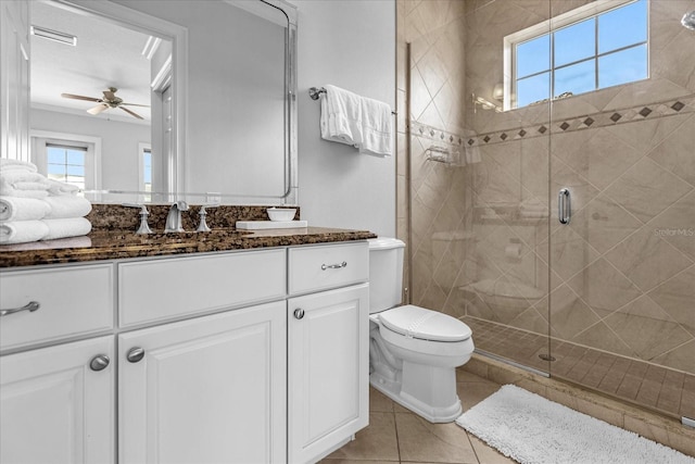 bathroom featuring a shower with door, ceiling fan, vanity, tile patterned floors, and toilet