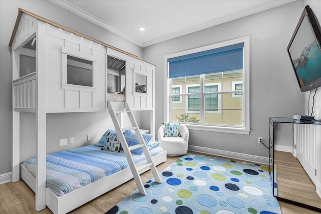 bedroom featuring ornamental molding and light wood-type flooring