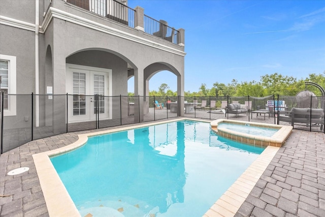 view of swimming pool with french doors, an outdoor living space, an in ground hot tub, and a patio area