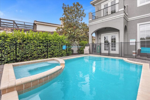 view of swimming pool with an in ground hot tub and french doors