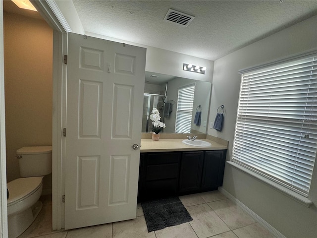 bathroom with tile patterned floors, toilet, a textured ceiling, and vanity