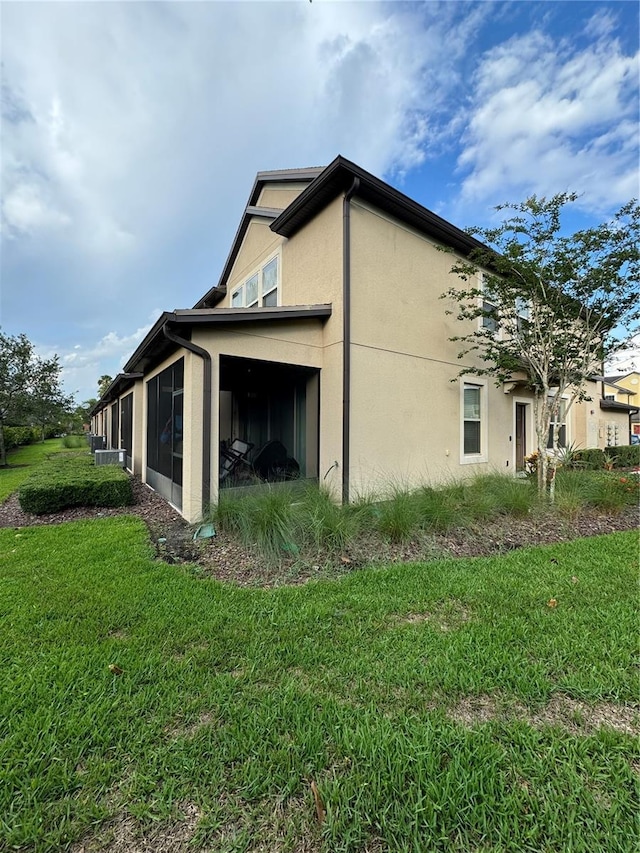 view of side of property featuring a sunroom and a yard