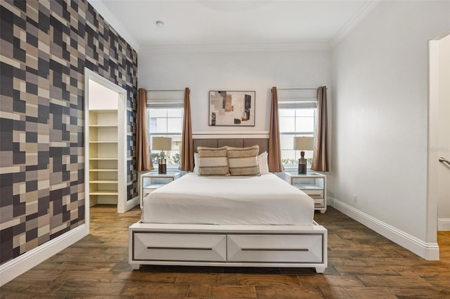 bedroom with ornamental molding, a spacious closet, and dark wood-type flooring