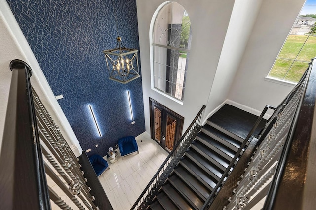 stairs featuring a chandelier