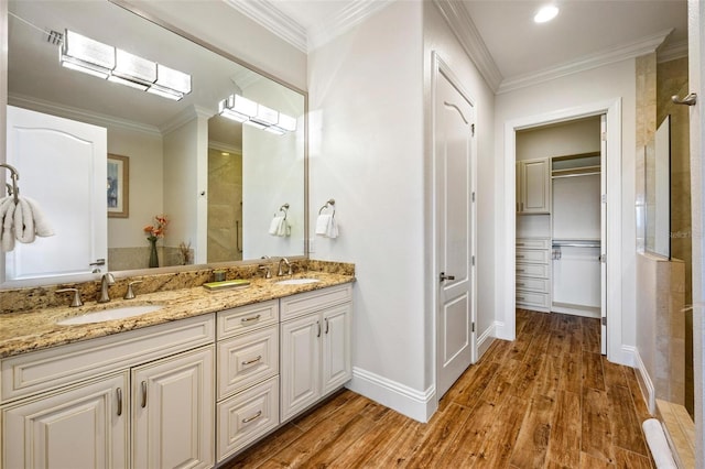 bathroom with crown molding, hardwood / wood-style floors, and vanity