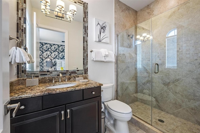 bathroom featuring decorative backsplash, walk in shower, vanity, a notable chandelier, and toilet