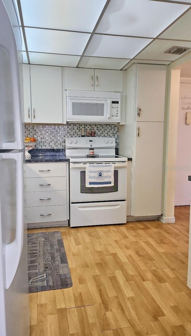 kitchen with light hardwood / wood-style floors, white appliances, white cabinetry, and backsplash