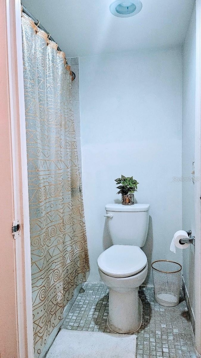 bathroom with tile flooring and toilet