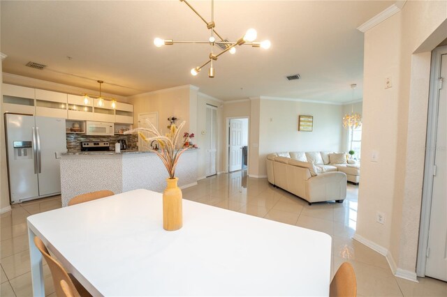 kitchen with tasteful backsplash, white appliances, crown molding, decorative light fixtures, and an inviting chandelier