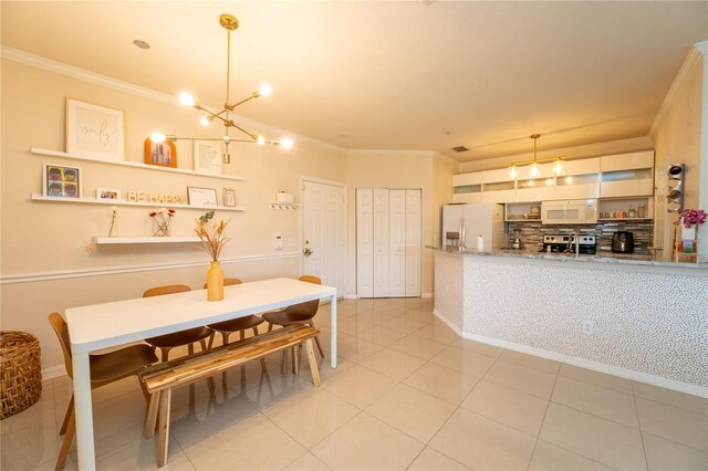 tiled dining area with ornamental molding and an inviting chandelier