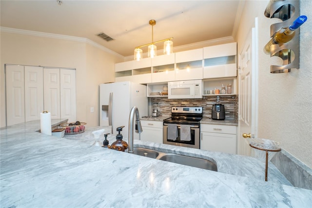 kitchen featuring white appliances, sink, hanging light fixtures, ornamental molding, and white cabinetry