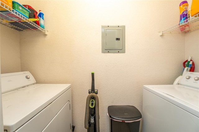 washroom with electric panel and washer and clothes dryer