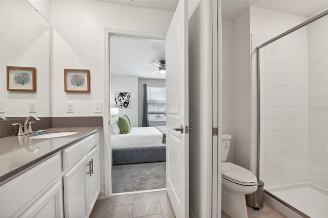 bathroom with ceiling fan, toilet, tiled shower, and vanity