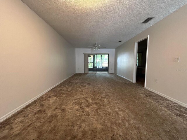 empty room with carpet flooring, ceiling fan, and a textured ceiling