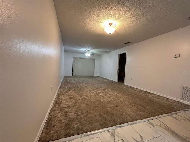 carpeted spare room with a textured ceiling