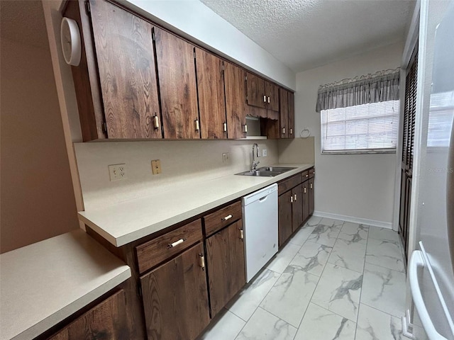 kitchen featuring sink, refrigerator, dark brown cabinets, a textured ceiling, and dishwasher