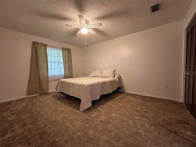 unfurnished bedroom featuring ceiling fan, a textured ceiling, and dark colored carpet