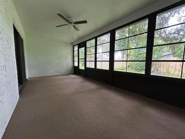 unfurnished sunroom with ceiling fan