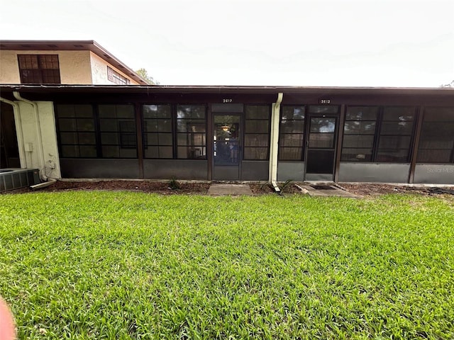 rear view of house featuring a lawn