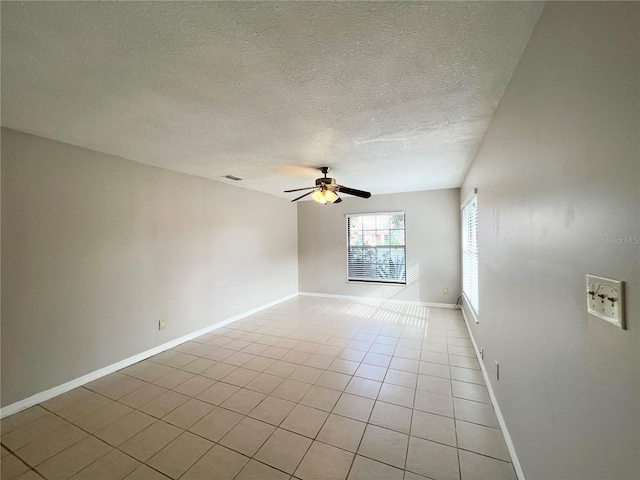 spare room with light tile patterned floors, a textured ceiling, and ceiling fan