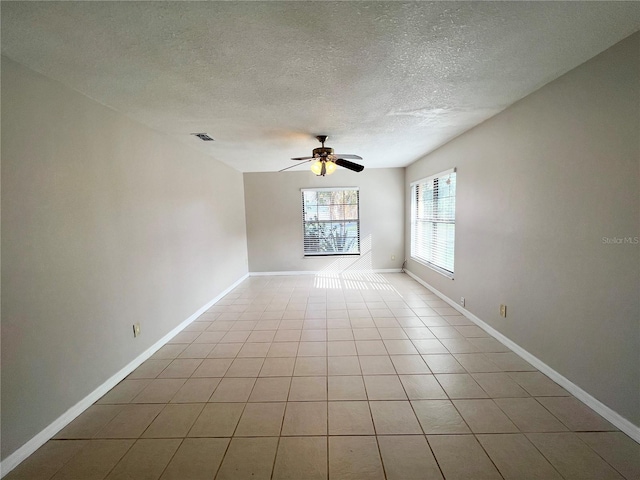 unfurnished room featuring ceiling fan, light tile patterned floors, and a textured ceiling