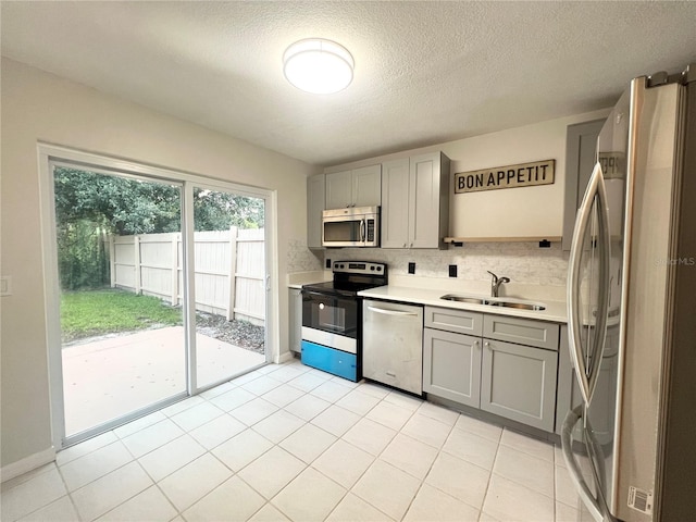 kitchen featuring gray cabinets, sink, a textured ceiling, and appliances with stainless steel finishes